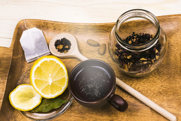 Citrus tea with lemon and biscuits on a wooden tray. Breakfast, morning.
