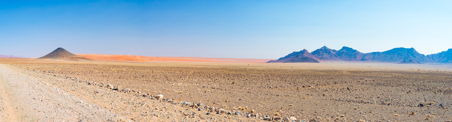 Colorful sand dunes and scenic landscape in the Namib desert, Namib Naukluft National Park, tourist destination in Namibia. Travel adventures in Africa. High resolution panorama.