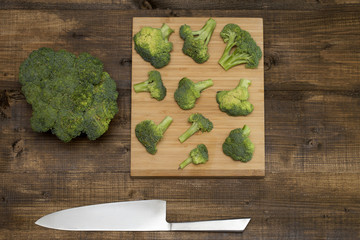 board with broccoli and knife on the table