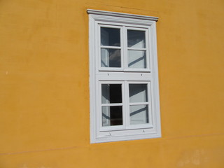 White window on yellow wall