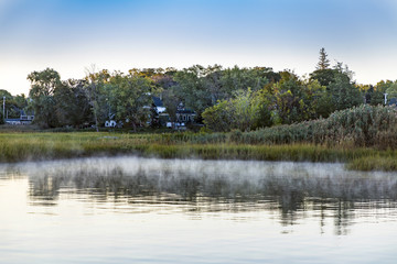 indian summer landscape with morning fog in small harbor village of Essex