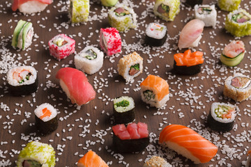 Set of sushi, maki and rolls with sesame on wooden rustic background