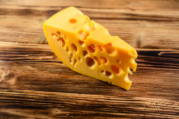 Piece of cheese on wooden table
