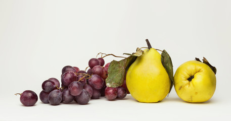 Black grapes and quince apples, isolated on white