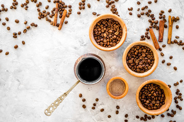 Make coffee in turkish coffee pot. Coffee beans, cinnamon on grey background top view copyspace