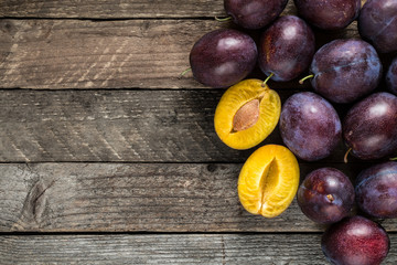 Fototapeta premium Fresh blue plums on wooden table