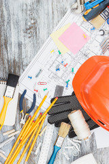 Drawings, yellow helmet and a construction belt with different construction tools