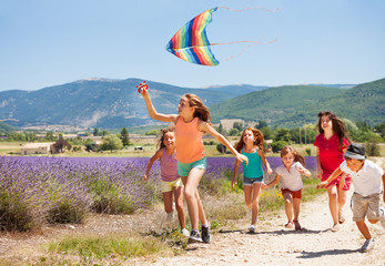 Kids having fun flying colorful kite in summer