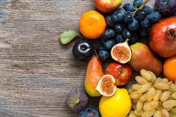 Naklejka na ściany i meble Juicy fresh fruit on a wooden dark table, top view.