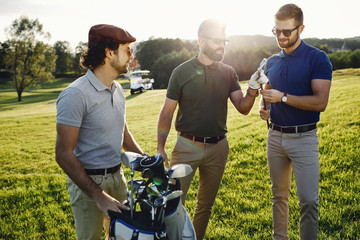 happy multiethnic golfers spending time together in golf course