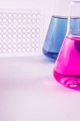  research, science and clinic background. 96 well micro plate and  laboratory beakers with colorful...
