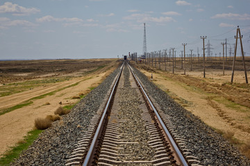 Fototapeta na wymiar Railroad track leading through the desert