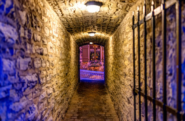 Lower old town with cobblestone street narrow alley Passage De La Batterie with light lamps at night twilight