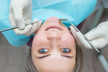 Naklejka premium Female patient at dentist examination, closeup portrait, beautiful woman smiling, view from above.
