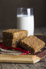 Stack of oatmeal crunchy cookies and milk in background