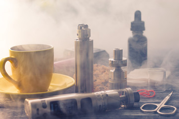 Still life with electronic cigarette with botle and coffe on the wooden background
