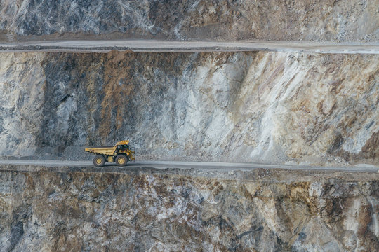 yeilow quarry truck on the road of a strip mining area