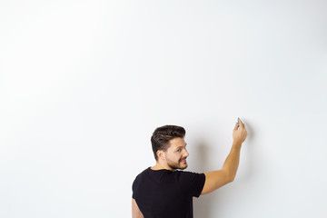 mann zeichnet an eine wand und blickt über die schulter zurück
