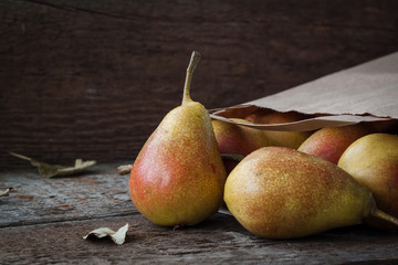 Red and yellow pears on a wooden background.