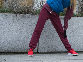 Sporty girl stretching outdoor on city street.