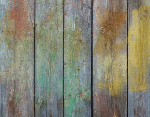 Old wooden wall texture with scratches, knots and multicolored paints. Natural background, retro fence.