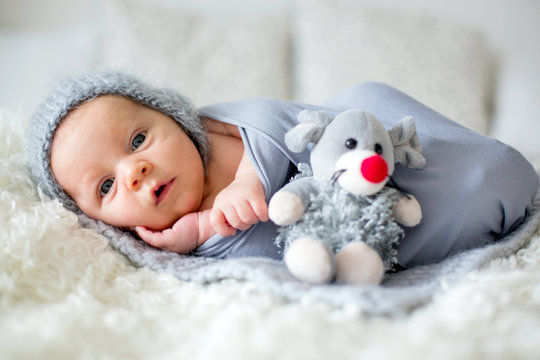 Little newborn baby boy, looking curiously at camera