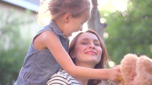 Happy mother and her daughter having fun outdoors. Slow motion. 4K UHD video 3840x2160