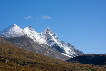 Snow-covered mountain peaks against clear blue  sky