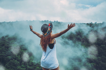 Asian women travel relax in the holiday. Stand up to receive rain.  Wild nature wood on the...