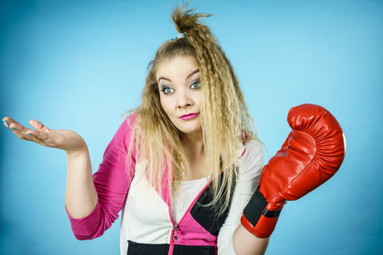 Funny confused woman wearing boxing glove