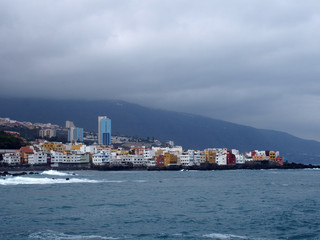 view across the bay in puerto cruz tenerife with mountains and waves