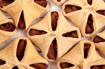Homemade plums pies close up. Many sweet plums on blurred background. Top view
