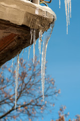 icicles hang from the roof of the balcony in the street in winter