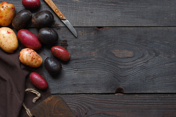 Wooden kitchen background with colorful potatoes