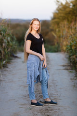 Outdoors lifestyle portrait of young adorable fresh looking redhead woman with freckles gorgeous extra long hair corn field sunny evening. Emotion and facial expression concept.