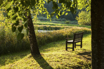 Naklejka premium Park bench in the autumn evening park