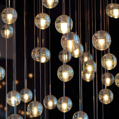  lighting balls on the chandelier in the lamplight,  light bulbs hanging from the ceiling, lamps on the dark background, selective focus, horizontal.