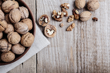 walnuts in a bowl on a wooden background