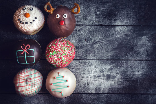 Homemade Christmas donuts on wooden background with blank space