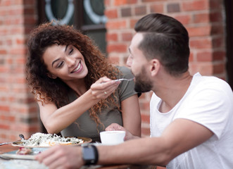 Young couple enjoying coffee at a street cafe and  laughing
