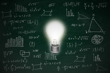 Chalkboard with math formula and idea concept bright glowing light bulb, inspiration and imagination on blackboard.