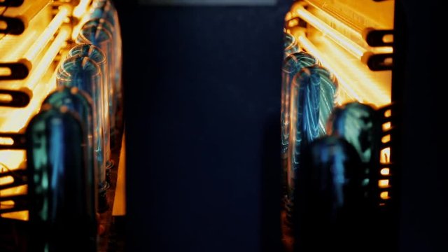 Plastic preforms pass through an infrared chamber for heating. Preform of bottles on rods pass through hot blocks in turn to prepare for blowing.