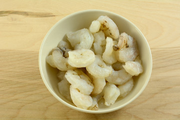 Raw peeled fresh shrimp in white bowl in preparation for cooking dinner