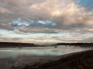 boat moored in estuary stream river dramatic sky autumn sunset country