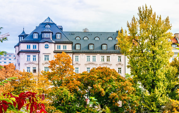 View on historical residential building before colorfull trees in autumn in Munich city