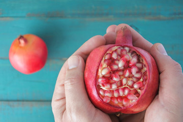 Man hands holds one Pomegranate Fruit with seeds