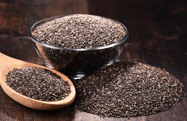 Composition with bowl of chia seeds on wooden table