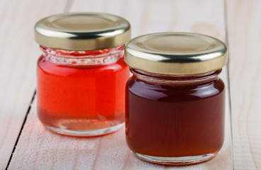 two jars of jam on a wooden table