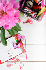 Planning concept for girl or woman with pink and red stationary over white wooden table