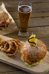 Hamburger and onion ring with glass of beer